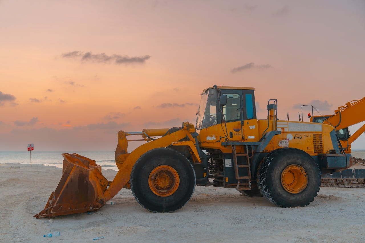 A bulldozer at a beach construction site during sunset, showcasing coastal development.